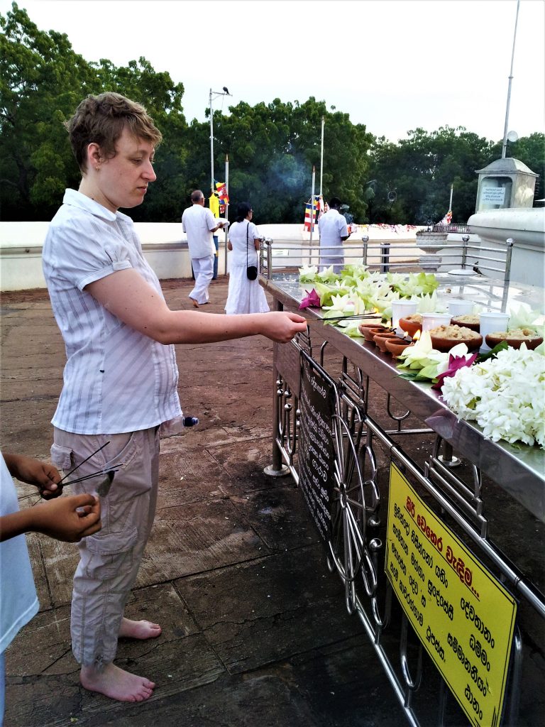 Lighting insense sticks at a temple in Sri Lanka. You'll note I am barefoot, and the clothing I am wearing, which is covering my knees and shoulders.